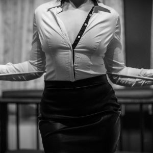 Lady Alexa mit Rohrstock und weißem Hemd als klassische Domina